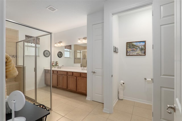 bathroom featuring vanity, a shower with shower door, and tile patterned flooring