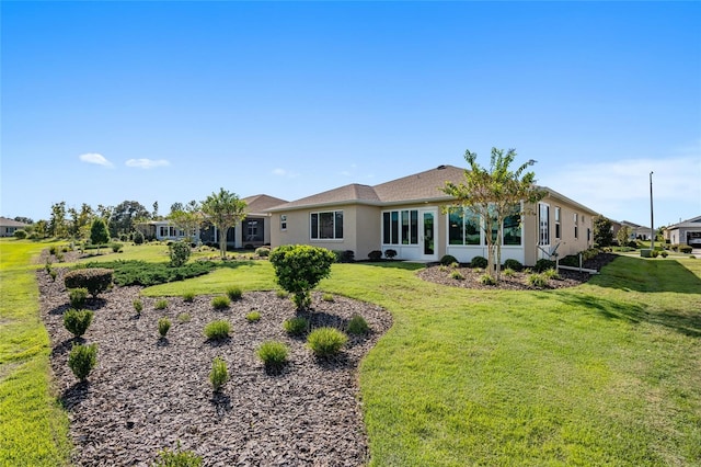 back of house featuring a sunroom and a lawn