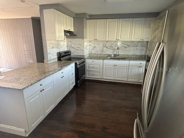 kitchen with light stone countertops, sink, dark hardwood / wood-style flooring, white cabinetry, and stainless steel appliances