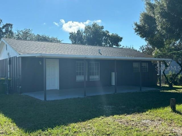 back of property featuring a patio area and a yard