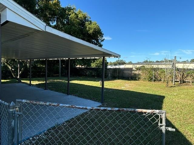 view of car parking featuring a lawn and a carport