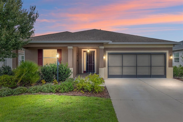 view of front of property featuring a yard and a garage