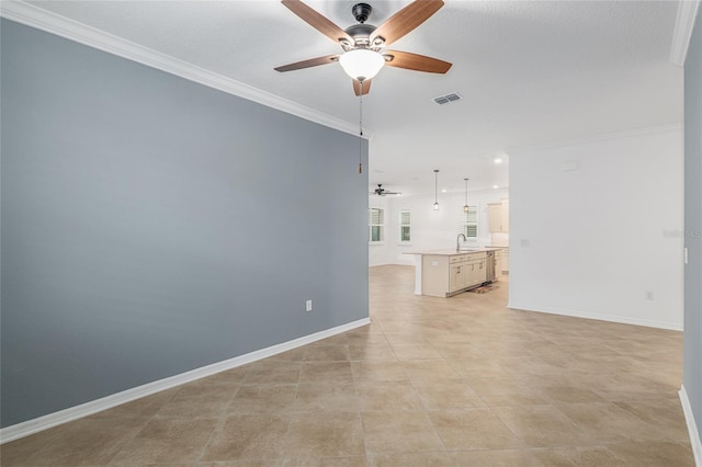 unfurnished room featuring ceiling fan, sink, ornamental molding, and light tile patterned flooring