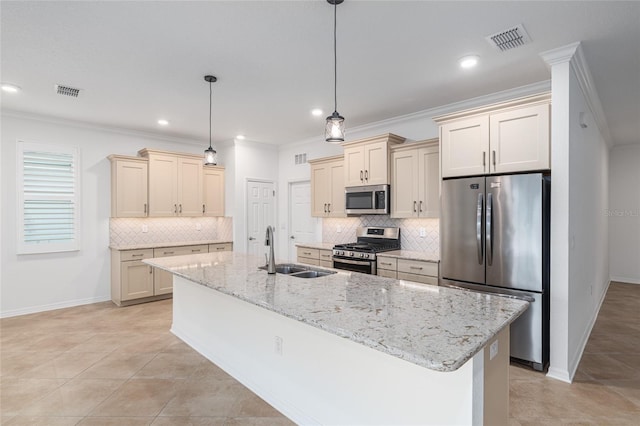 kitchen with sink, cream cabinets, decorative light fixtures, a center island with sink, and stainless steel appliances