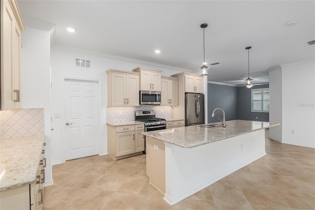 kitchen featuring light stone counters, sink, cream cabinetry, a center island with sink, and appliances with stainless steel finishes