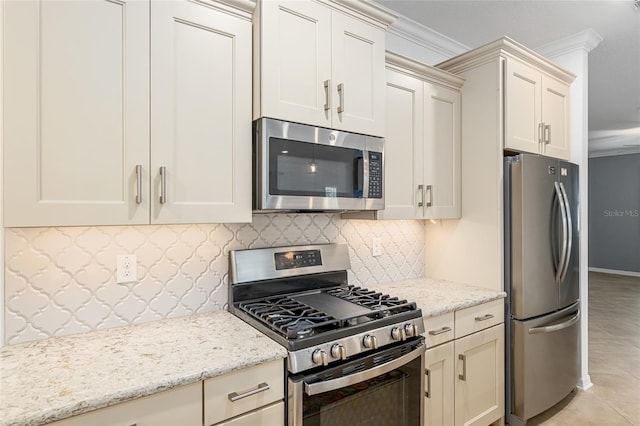 kitchen featuring appliances with stainless steel finishes, light stone counters, tasteful backsplash, light tile patterned floors, and crown molding