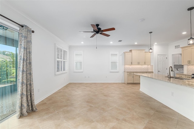 unfurnished living room with light tile patterned floors, ornamental molding, sink, and ceiling fan