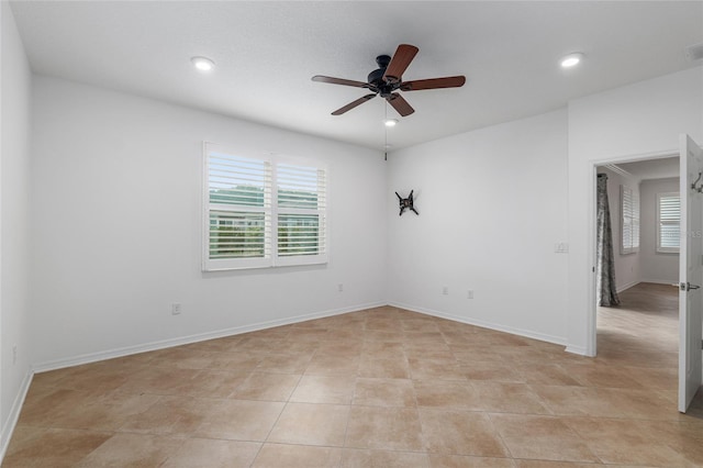 tiled spare room with ceiling fan