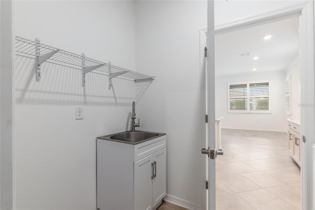 clothes washing area with light tile patterned floors and sink