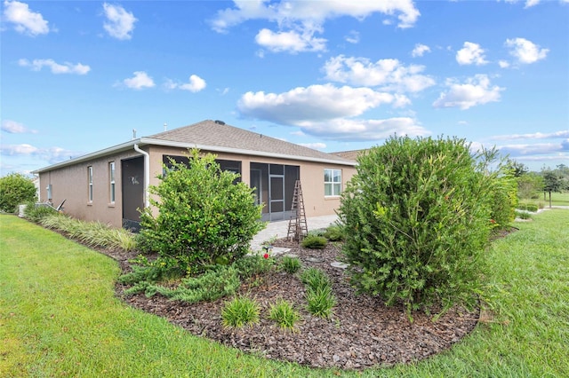 7709 SW 86th Ct, Ocala, FL 34481 - rear view of property featuring stucco siding, a lawn, and a sunroom