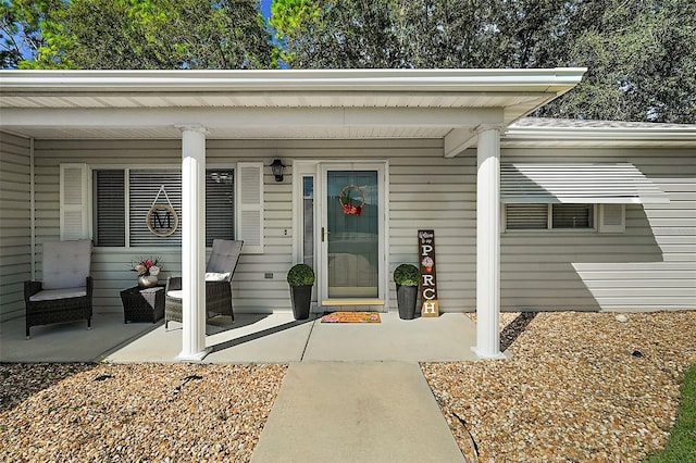 view of exterior entry featuring covered porch