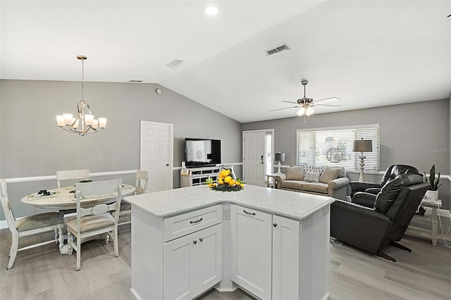 kitchen featuring white cabinetry, hanging light fixtures, a kitchen island, ceiling fan with notable chandelier, and light wood-type flooring