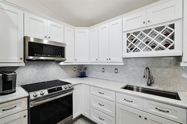 kitchen featuring white cabinets, appliances with stainless steel finishes, tasteful backsplash, and sink