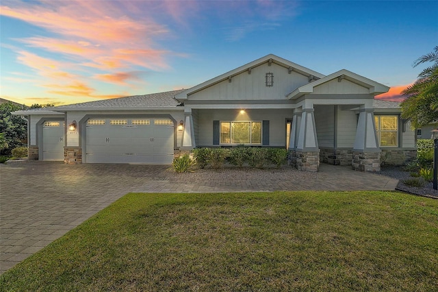 craftsman-style home with a yard, covered porch, and a garage