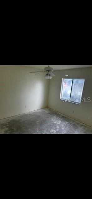 empty room featuring ceiling fan and concrete floors