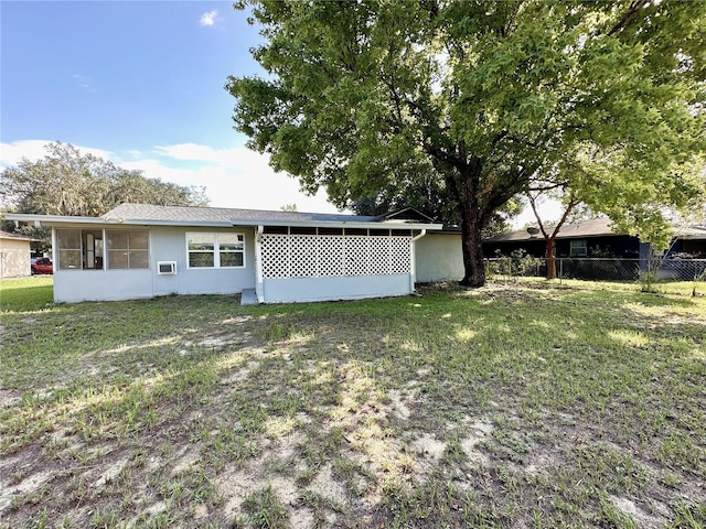 back of property featuring a sunroom and a yard