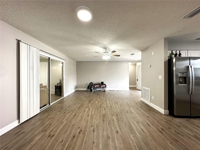 unfurnished living room with a textured ceiling, wood-type flooring, and ceiling fan