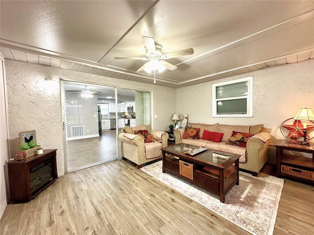 living room featuring light hardwood / wood-style floors and ceiling fan