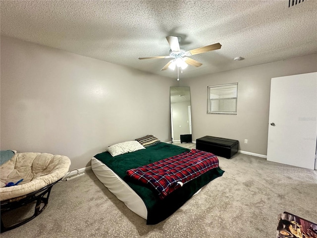 carpeted bedroom with ceiling fan and a textured ceiling