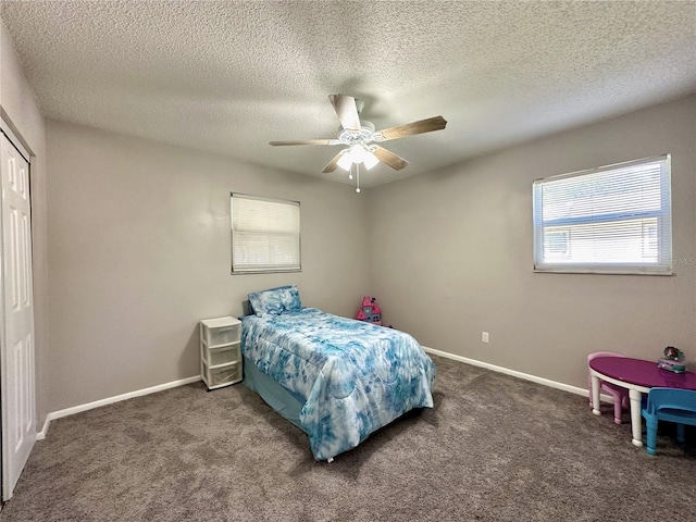 bedroom featuring ceiling fan, a textured ceiling, and dark colored carpet