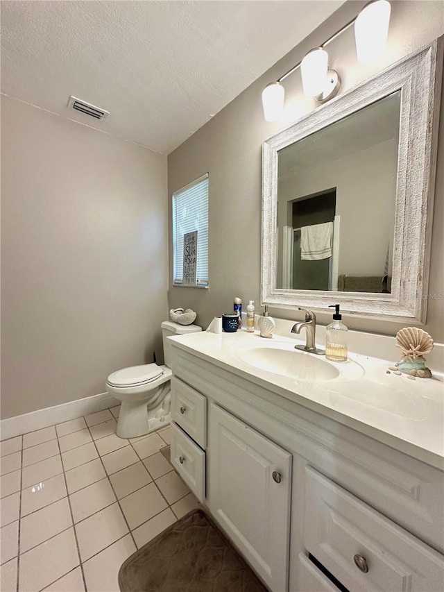 bathroom featuring a textured ceiling, vanity, toilet, and tile patterned floors