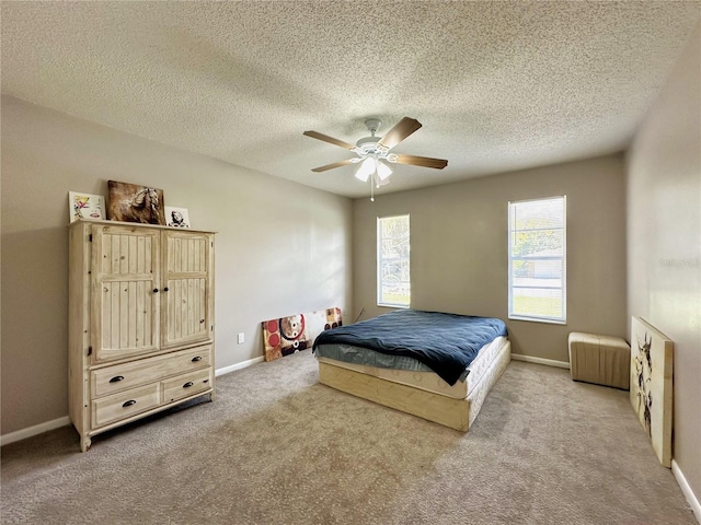 carpeted bedroom with ceiling fan and a textured ceiling