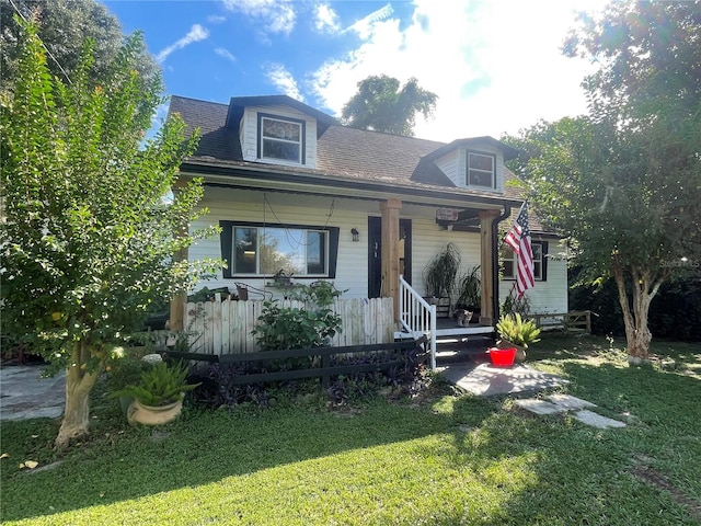 cape cod home with a front lawn and covered porch