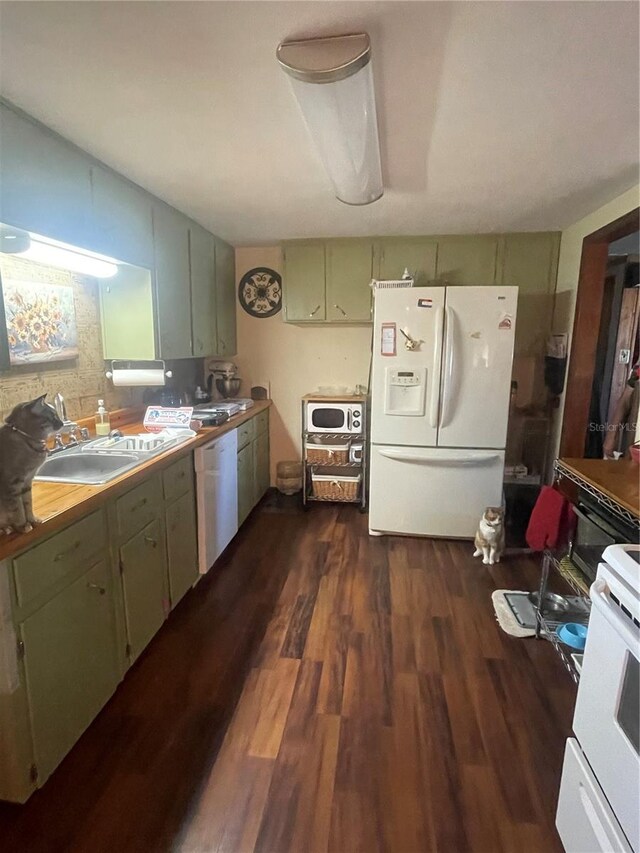 kitchen featuring green cabinetry, white appliances, sink, and dark hardwood / wood-style flooring