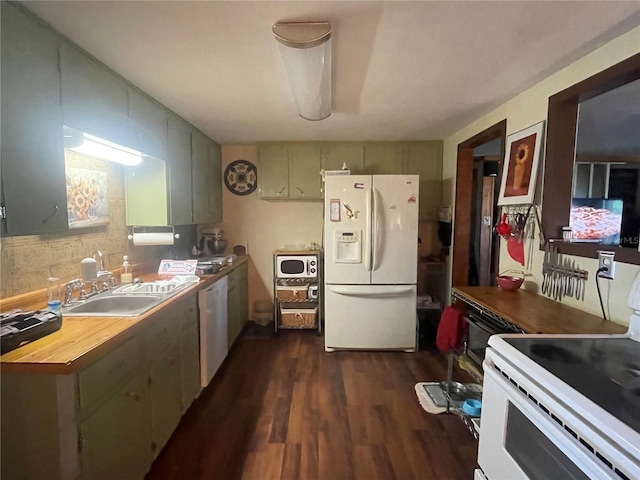 kitchen with butcher block countertops, a sink, dark wood-style floors, and white appliances