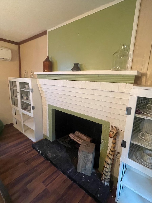 room details featuring ornamental molding, a wall unit AC, wood finished floors, and a fireplace