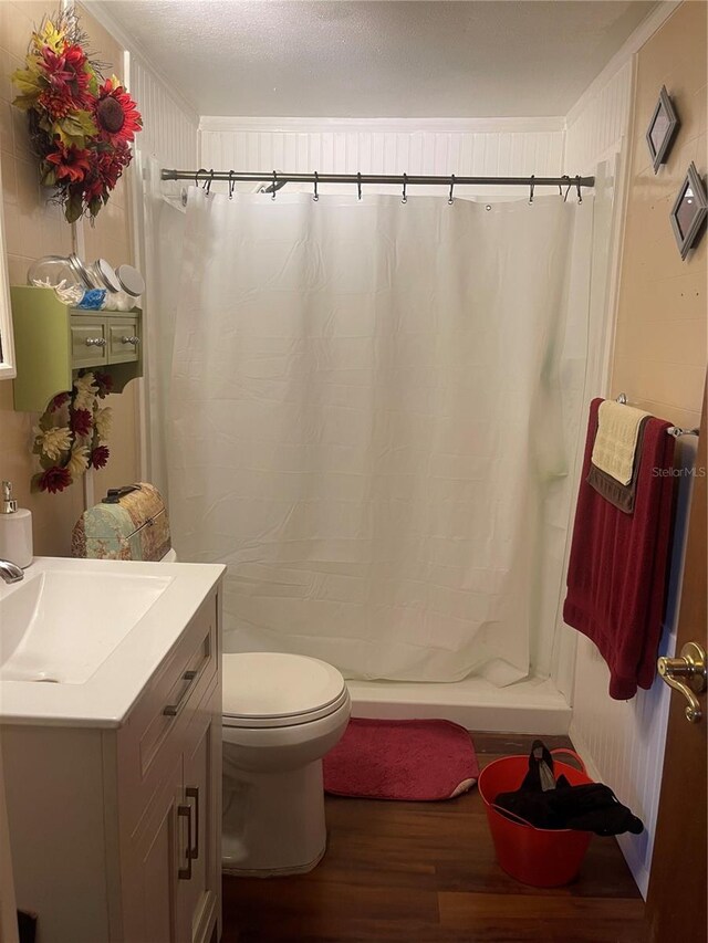 bathroom featuring vanity, toilet, crown molding, hardwood / wood-style floors, and a shower with shower curtain