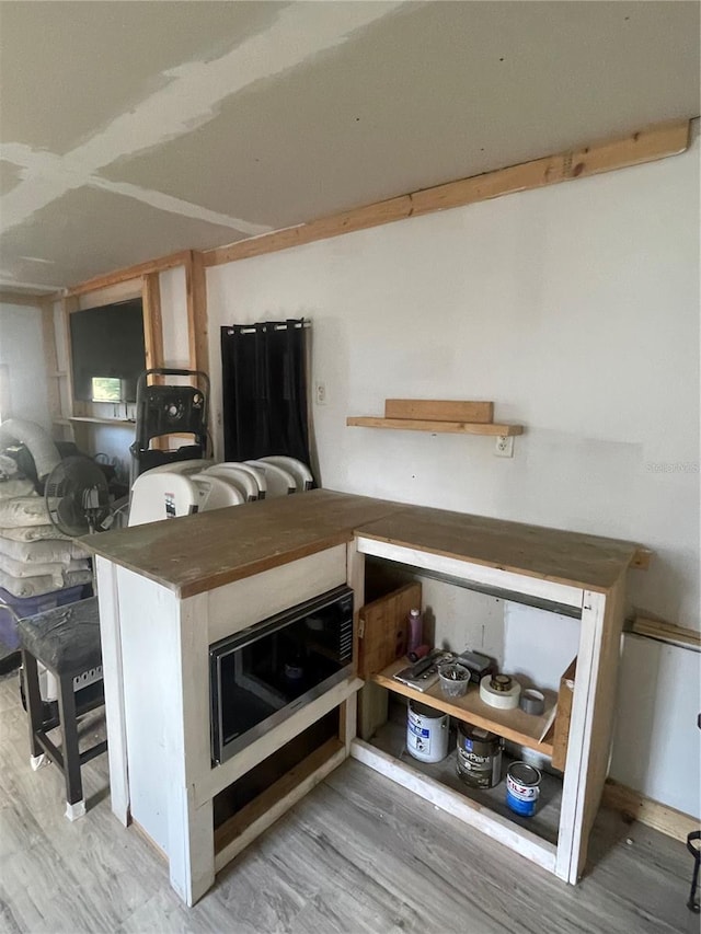 kitchen with light wood-type flooring and built in microwave