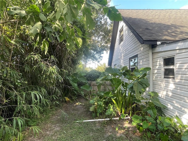 view of property exterior with a shingled roof