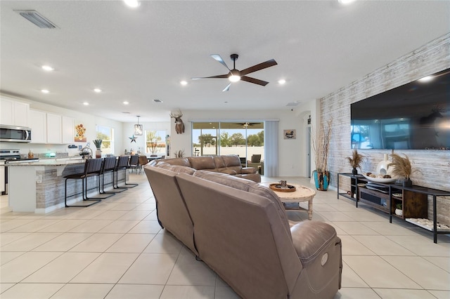 tiled living room with ceiling fan