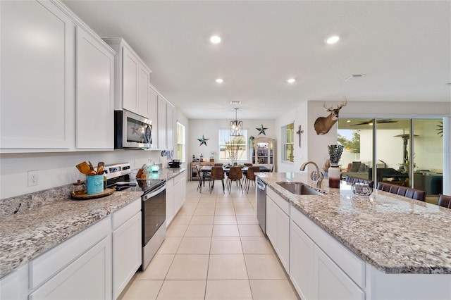 kitchen with an island with sink, white cabinetry, sink, and stainless steel appliances