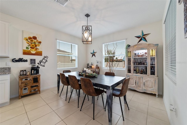 dining area with light tile patterned flooring and a notable chandelier