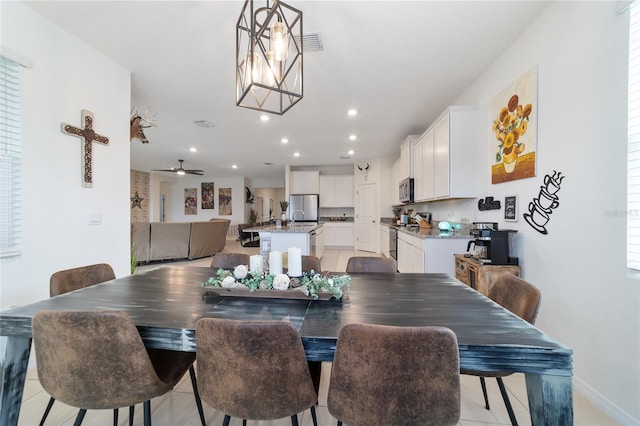 tiled dining area with ceiling fan with notable chandelier and plenty of natural light