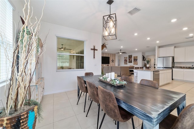 dining space featuring light tile patterned flooring, sink, and ceiling fan