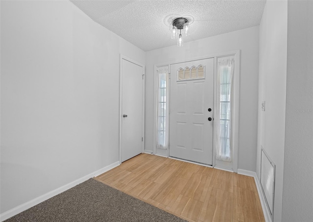 entryway with wood-type flooring and a textured ceiling