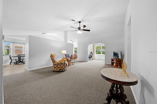 sitting room featuring ceiling fan, carpet floors, a textured ceiling, and a wealth of natural light