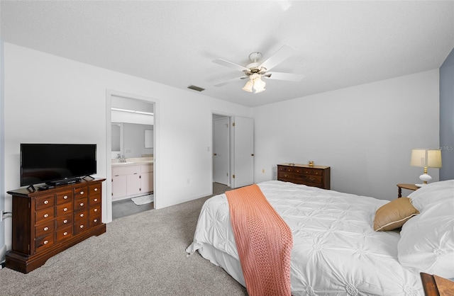 bedroom with ensuite bathroom, a textured ceiling, ceiling fan, sink, and carpet floors