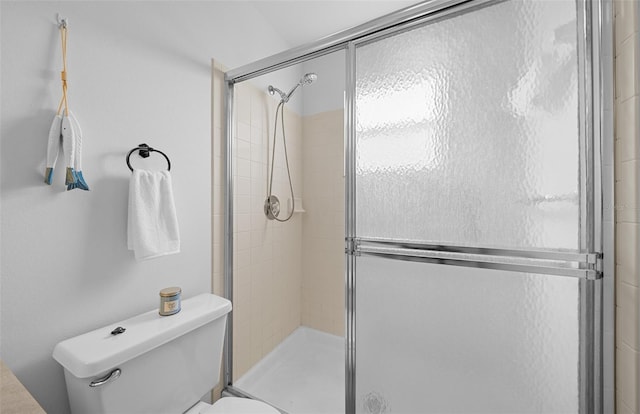 bathroom with toilet and a shower with shower door