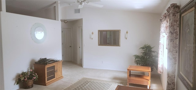 interior space featuring ceiling fan, light colored carpet, and lofted ceiling