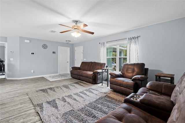 living room featuring a textured ceiling, hardwood / wood-style floors, and ceiling fan