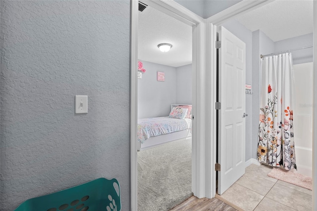 interior space featuring a textured ceiling, shower / bath combo with shower curtain, and hardwood / wood-style floors