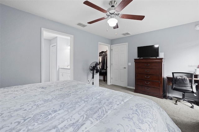 carpeted bedroom featuring a spacious closet, a closet, ceiling fan, and ensuite bathroom