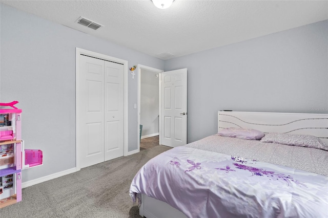 bedroom featuring a textured ceiling, dark carpet, and a closet