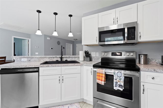 kitchen with stainless steel appliances, white cabinetry, hanging light fixtures, and sink