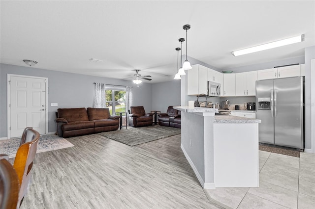 kitchen with ceiling fan, pendant lighting, light hardwood / wood-style flooring, white cabinetry, and stainless steel appliances