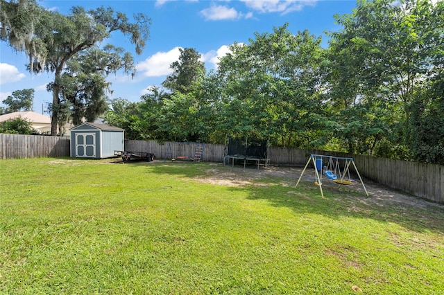 view of yard featuring a trampoline, a storage shed, and a playground